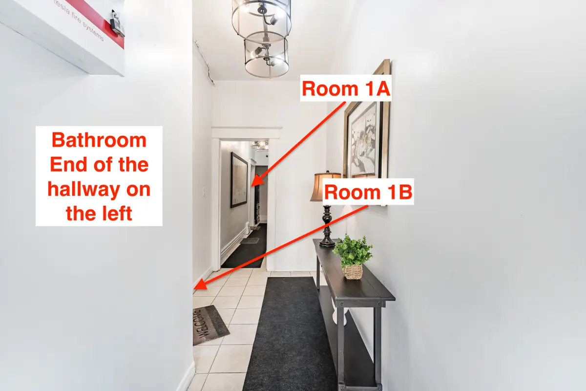 Hallway: Room 1A is at the end. The bathroom is at the end of the hallway on the left.