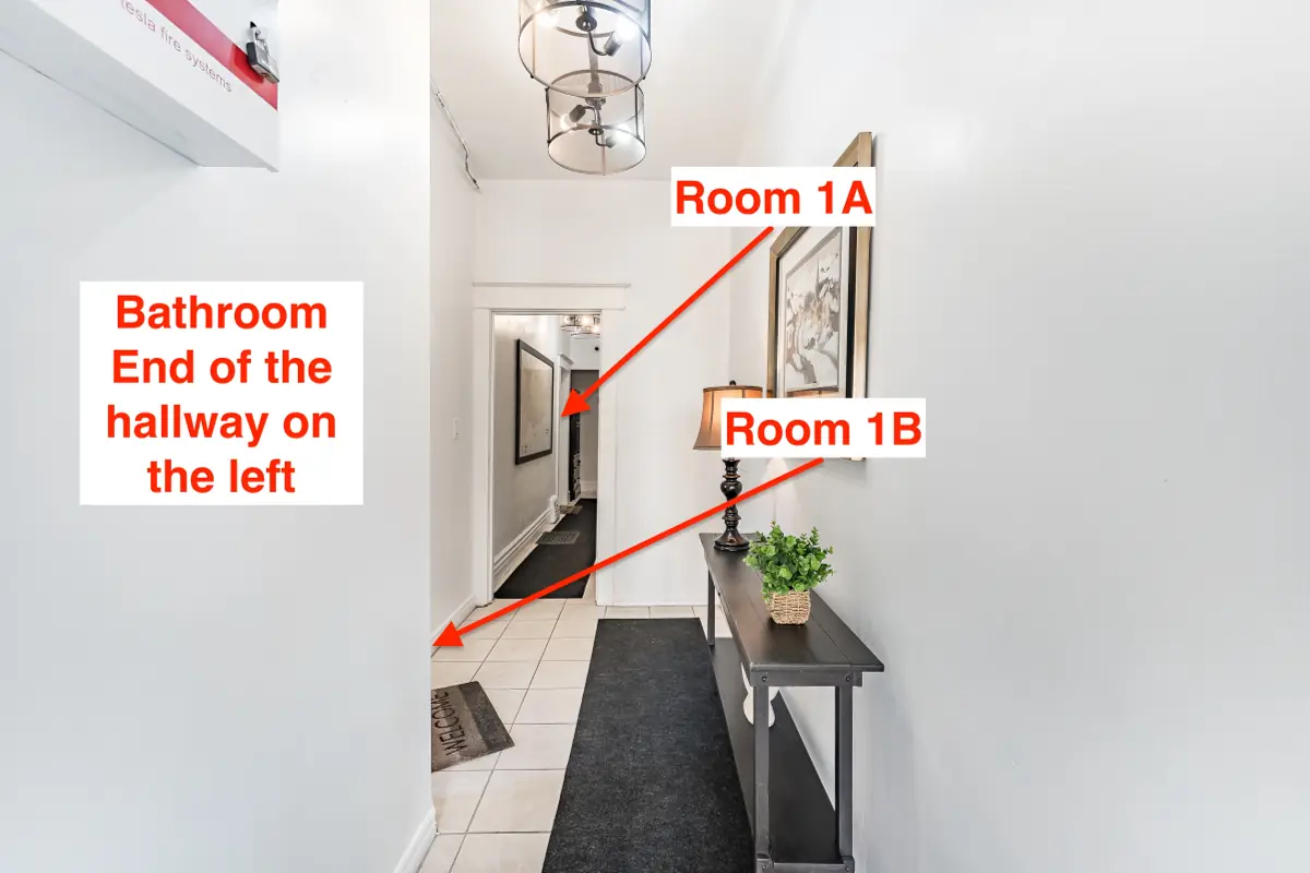 Hallway: Room 1A at the end, Room 1B on the left, and the bathroom at the end of the hallway on the left.