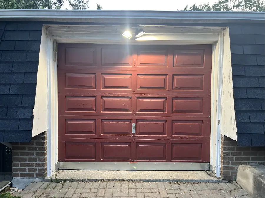 Red garage door. The garage door opener is on the left side of the door.